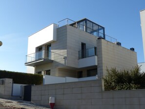 A modern multi-story building with balconies, a flat roof, and a clear sky. - Villa d'ARCHITECTE, Sur les hauteurs, VUE MER, calme, TERRASSE 360°.   (casal mota)