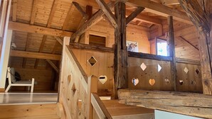Un intérieur en bois avec un escalier, un banc et une chaise.
