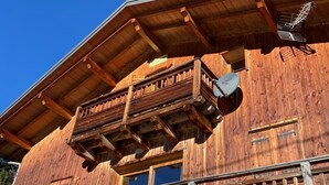 Un bâtiment en bois doté d’un balcon et d’une antenne parabolique.