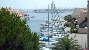 A marina with boats docked, surrounded by buildings and greenery. - Grand T3 luxury duplex in highly sought after residence (Gruissan)