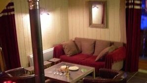 A cozy living room with a sofa, a coffee table, and a fireplace.