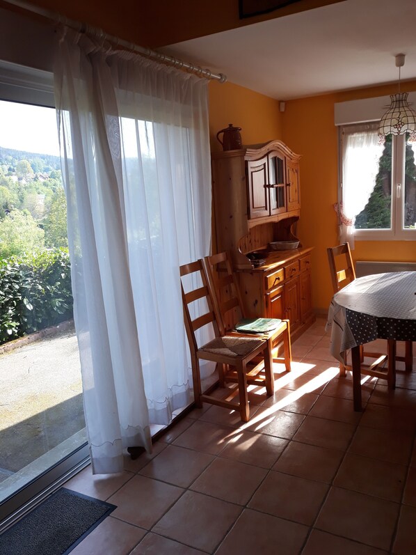 Un comedor con mesa, sillas y vista al exterior.