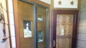 Een houten deur met een raam erboven, een klein tafeltje en een decoratief wiel.