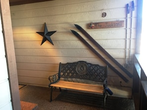 A wooden bench with metal legs, a star decoration, and a sign reading "The Jacksons" on a wooden wall. - Cedars 9 (Angel Fire)