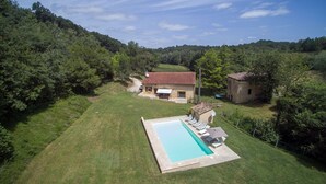 A house with a swimming pool, surrounded by lush greenery and hills. - Charming 4-star Gite with pool (Capdrot)