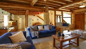A spacious living area with a wooden ceiling, a sofa set, a coffee table, and a staircase leading to an upper level. - Charming 4-star Gite with pool (Capdrot)