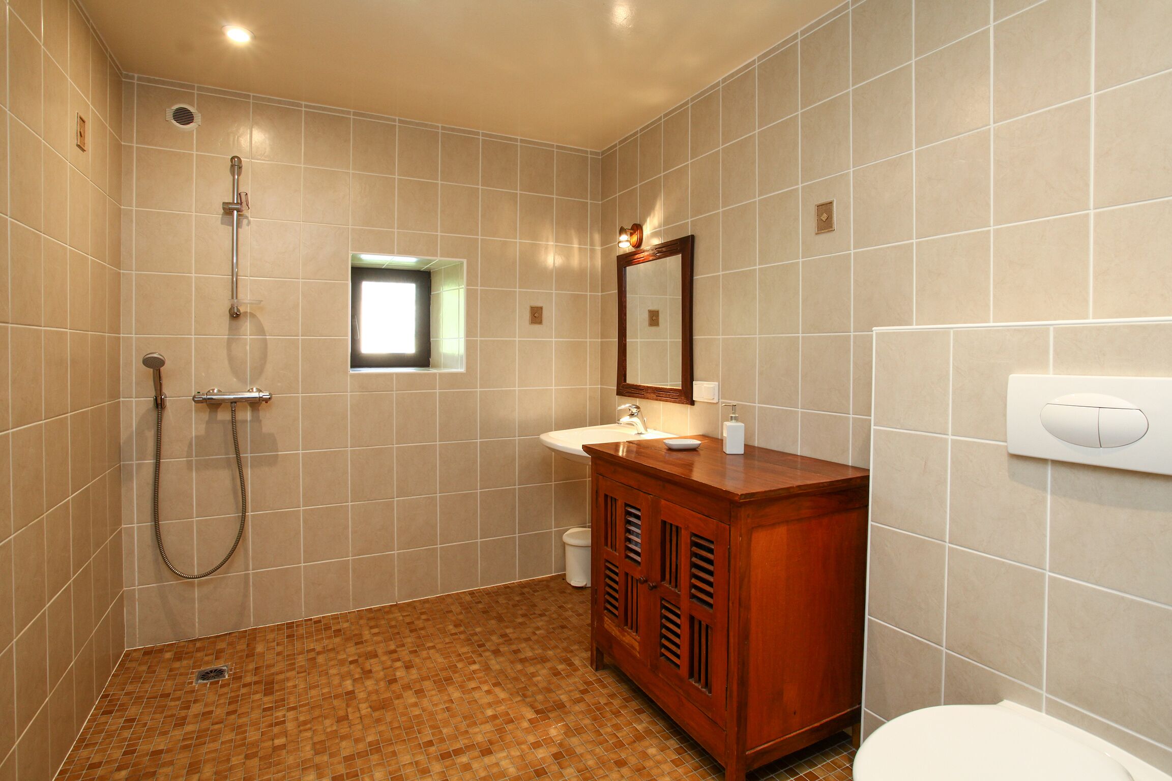 A bathroom with a shower, sink, vanity, and toilet.