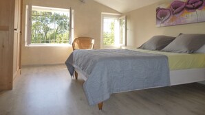 A bedroom with a bed, two windows, a chair, and a painting. - Country house with large garden and swimming pool (Carces)