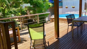 A wooden deck with a pool, a chair, and a table. - Between sea and rivers, at the gates of the Guadeloupe National Park! (capesterre belle eau)