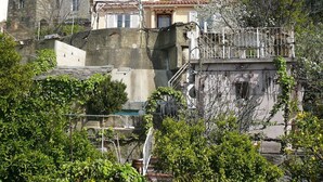 A building with multiple stories, stone walls, and a balcony with metal railings. - Sunny villa with stunning views over the village and the sea (Oletta)