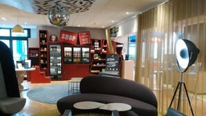 Ett modernt loungeområde med en soffa, två små bord och en golvlampa.