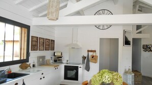 Eine moderne Küche mit weißen Schränken, einem Holzespeisetisch und einer Uhr an der Wand.
