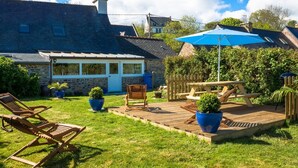 A backyard with a wooden deck, a covered patio, and a stone building with a window. - Old stone house between Crozon and Camaret (sea 200m) (Crozon)