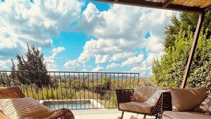 A patio with wicker furniture, a dining table with breakfast items, and a pool in the background. - Adorable villa with private swimming pool and a superb view of the mountains (Eyragues)