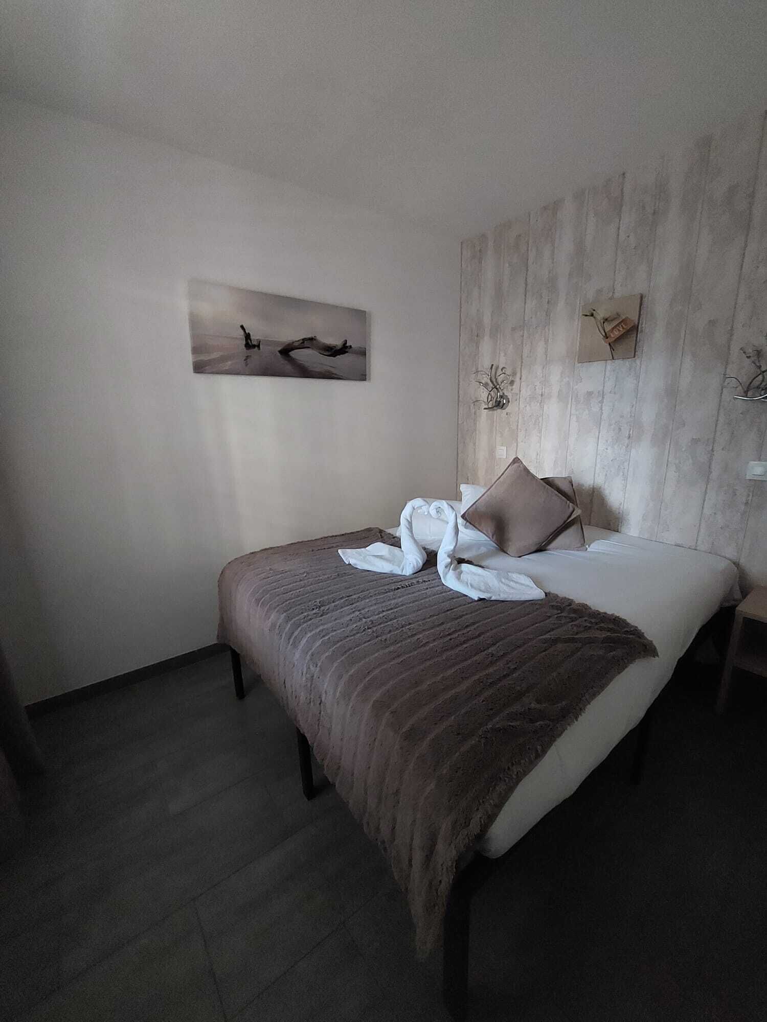 Ein Schlafzimmer mit einem Bett, einem Kissen, einer Decke und einem Wandbild.