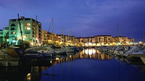 A marina at dusk with boats docked, buildings with balconies, and a calm water surface reflecting the lights. - Completely renovated house with swimming pool, garden, parking, A/C, in Argelès (Argelès-Sur-Mer)