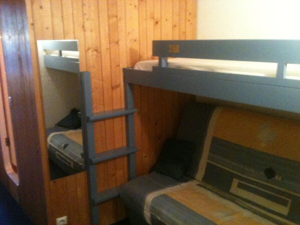 A bunk bed room with a ladder, wooden walls, and a small window. - Charming studio in Arcs 1800, at the foot of the slopes, in the heart of the village (Bourg-Saint-Maurice)