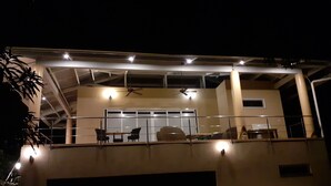 Une maison moderne dotée d’un patio couvert, d’une piscine et d’un garage.