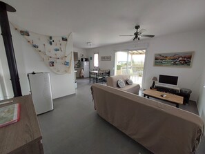 A compact living space with a kitchenette, a dining area, a sofa, and a TV. - Holiday house near La Palmyre in quiet area -View on the countryside- (Arvert)