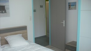 Ein Schlafzimmer mit einem Bett, einem Kleiderschrank und einer Tür zu einem Badezimmer.