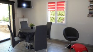 A modern dining area with a round table, black chairs, a potted plant, and a red chair. - Provence, its lavender, the song of the cicadas, the sun ... Let yourself be seduced ... (Carpentras)