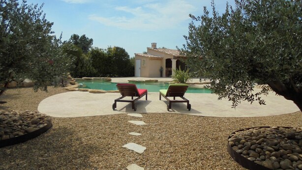 A pool area with two lounge chairs, a stone pathway, and a building in the background. - Provence, its lavender, the song of the cicadas, the sun ... Let yourself be seduced ... (Carpentras)