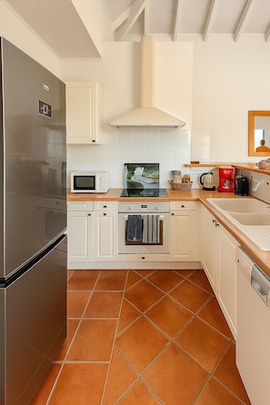 A kitchen with white cabinets, a stainless steel refrigerator, a microwave, a stove, and a sink. - Villa in the heart of Orient Bay. Beach and restaurants: 3–4 minutes on foot (baie orientale)