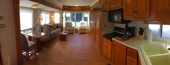 A compact RV interior with a kitchenette, dining area, and seating space. - Water View, 100 Fishing Dock! Teton 40 Ft. Trailer W/3 Slide Outs. (Palmetto)