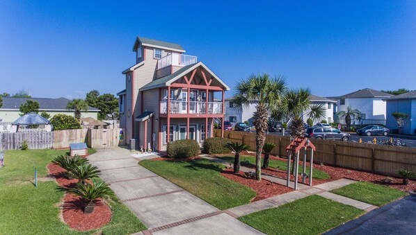 A two-story house with a balcony, a fenced backyard, and a well-maintained lawn. - Experience tranquility steps away from Miramar Beach (Miramar Beach)