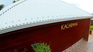 A building with a corrugated metal roof and the name "KACHIMAN" on its side. - Pretty country bungalow (Saint-Esprit)