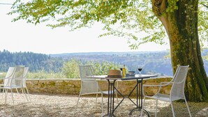 A table and chairs set outdoors with a view of a mountainous landscape. - Maison de Caractère with swimming pool Unbeatable view (Saint-Victurnien)