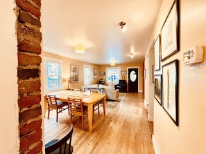 Cozy living and dining space with a dining table, sofa, and artwork on the walls.