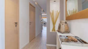 A hallway with wooden flooring, a white door, and a mirror on the wall. - Want to GET AWAY from it all by the sea in GOLFE JUAN? (Vallauris)