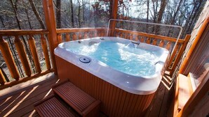 Eine Holzterrasse mit Whirlpool und einer Holzbank.
