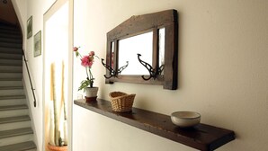 Una estantería de madera con un espejo, una cesta y un cuenco.