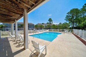 Un espace piscine couvert avec des chaises longues et une pergola en bois.