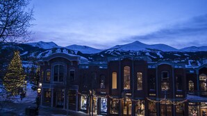 A historic building with large windows and a snow-covered mountain backdrop.