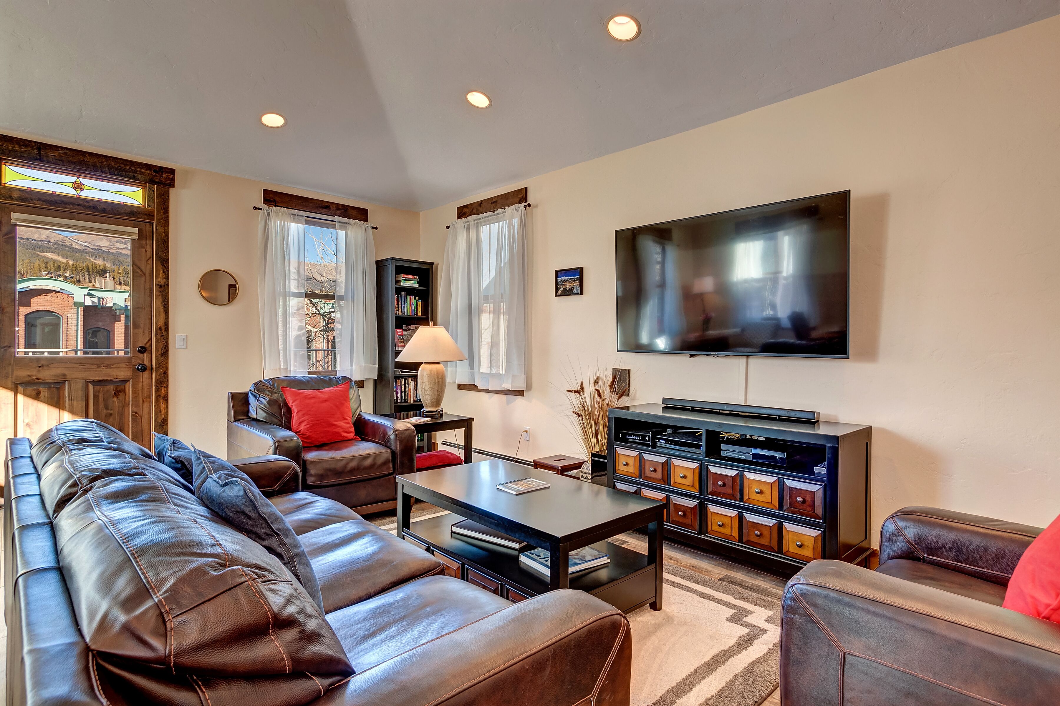 A living room with a sofa, coffee table, TV, and a bookshelf.
