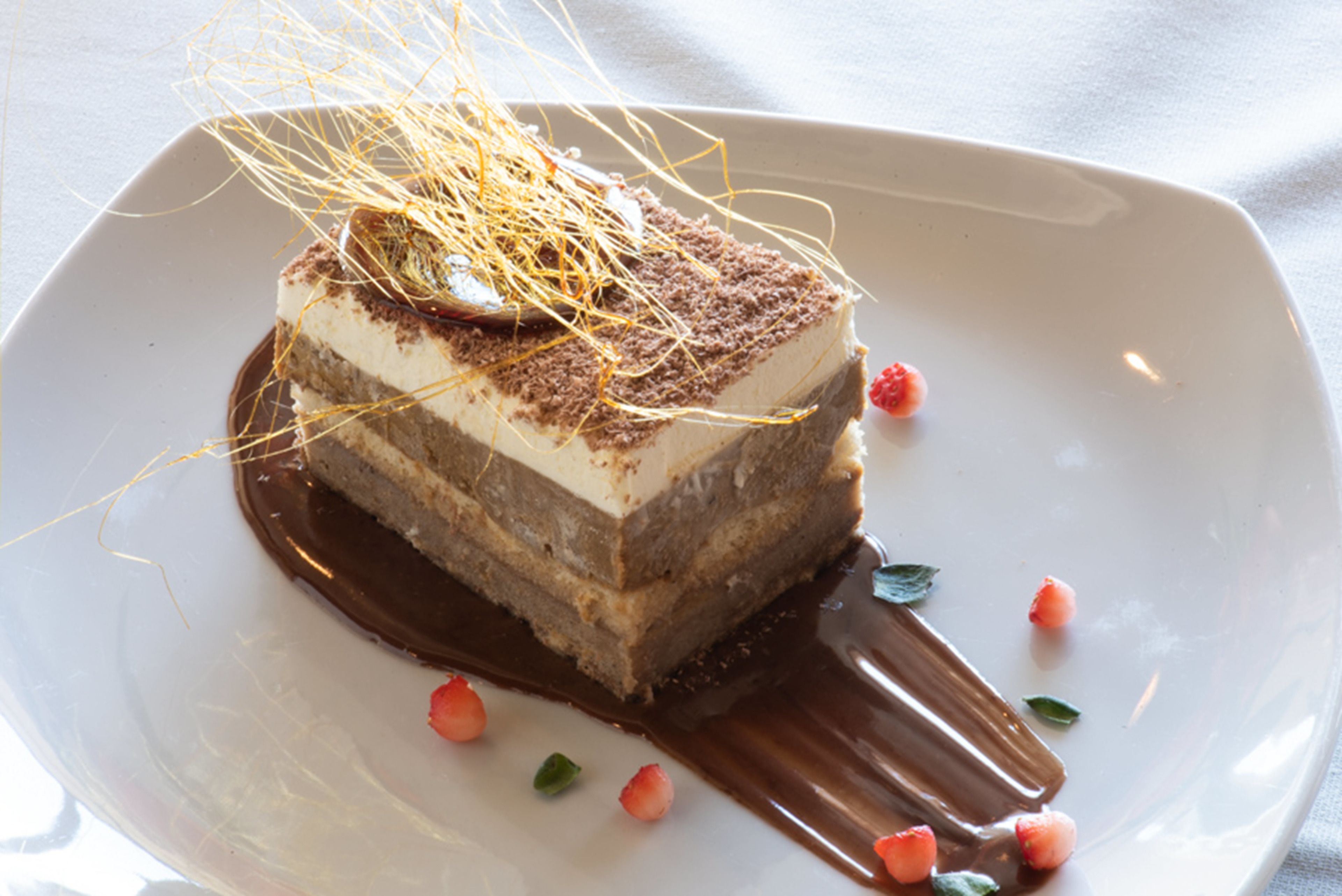 Un postre en un plato con salsa de chocolate y fresas.