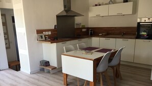 A modern kitchen with white cabinets, a wooden countertop, and a Bosch oven. - BEAUTIFUL VILLA WITH HEATED JACUZZI AND WIFI, facing the golf course in Lacanau-Océan; sleeps 6, 3 bedrooms, 2 bathrooms (Lacanau)