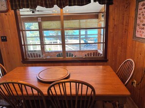A wooden dining table with chairs, a window with blinds, and a wall-mounted clock. - Lakefront Home with Onsite Boat Launch!  Great Fishing!  Very Relaxing! (Many)