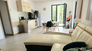Ein modernes Wohnzimmer mit einer beigefarbenen Ledersofa, einem Holztisch und einem Essbereich mit Tisch und Stühlen.