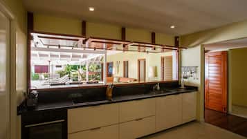 Una cocina moderna con una isla grande, electrodomésticos integrados y vistas al patio exterior.