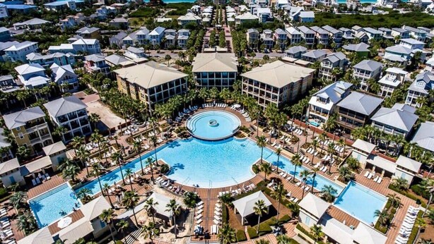 Ein Resort mit mehreren Schwimmbecken, einem zentralen Rundbecken und Blick auf den Ozean.