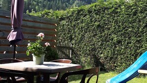 Ein Sitzbereich im Freien mit Tisch, Stühlen und einem Blumentopf.
