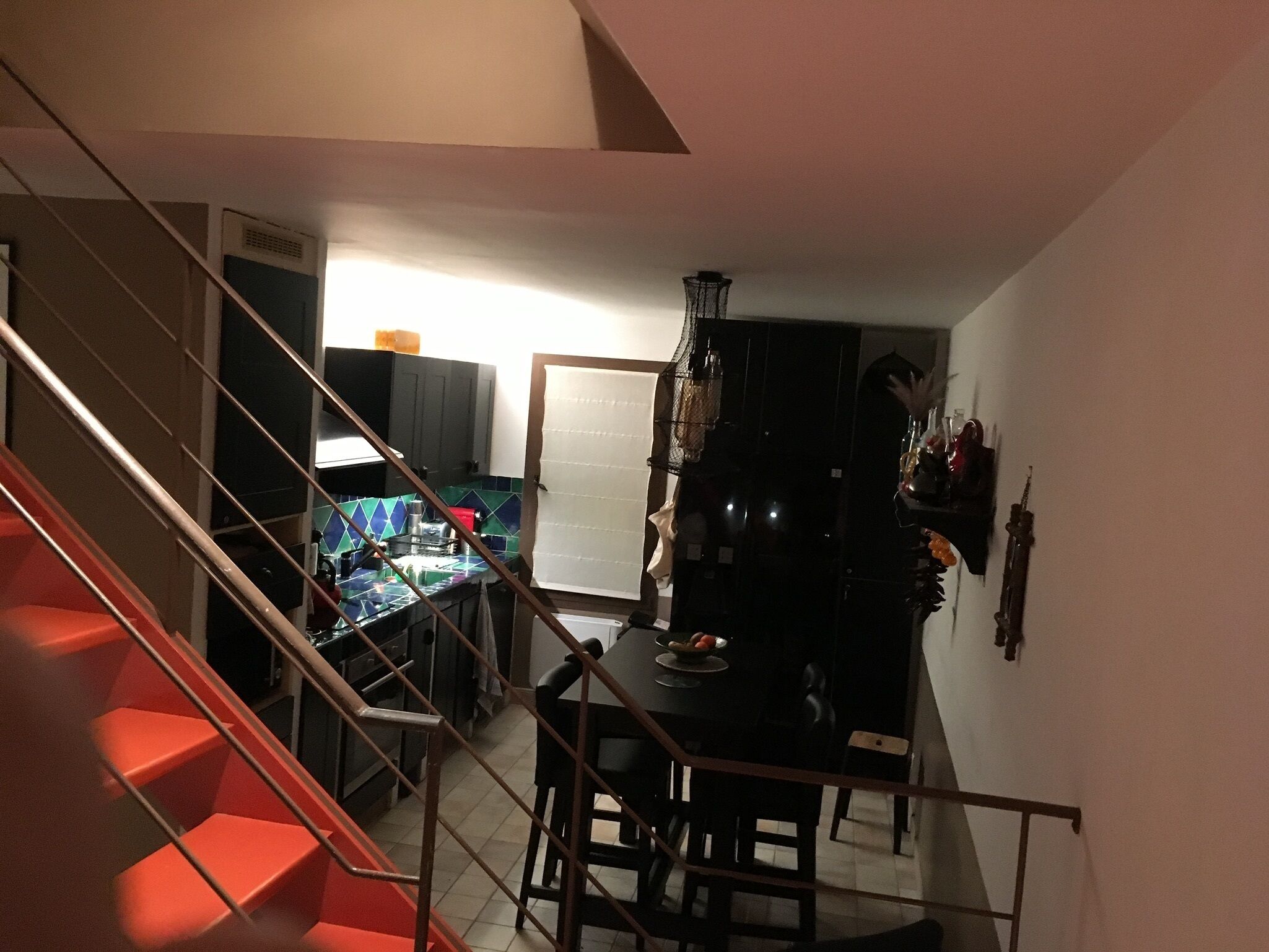 A staircase leading to a dining area with a table and chairs.
