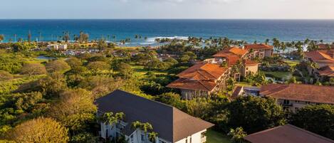 A coastal resort with multiple buildings, a view of the ocean, and lush greenery.