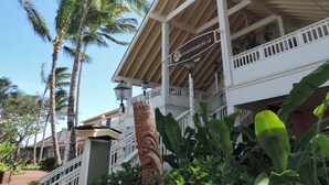 Un hôtel doté d’un balcon, de palmiers et d’une enseigne indiquant « Merriman’s ».