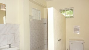Ein Badezimmer mit Waschbecken, Toilette und Duschbereich.