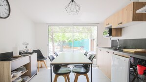 Una cucina moderna con tavolo, sedie e lavastoviglie.